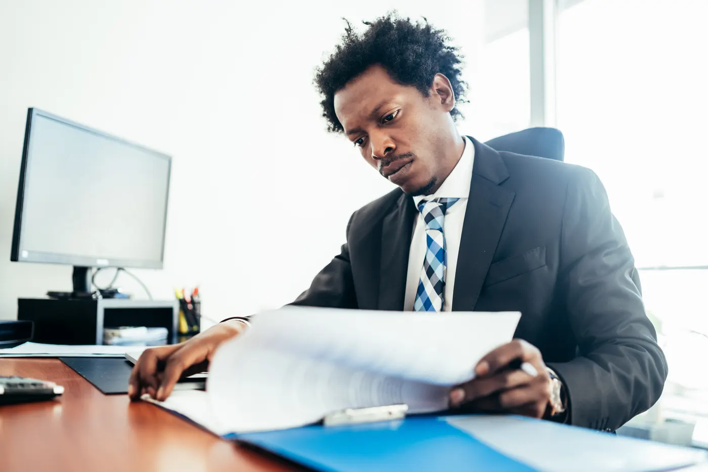 Professional businessman working with some files and documents at his modern office. Business concept