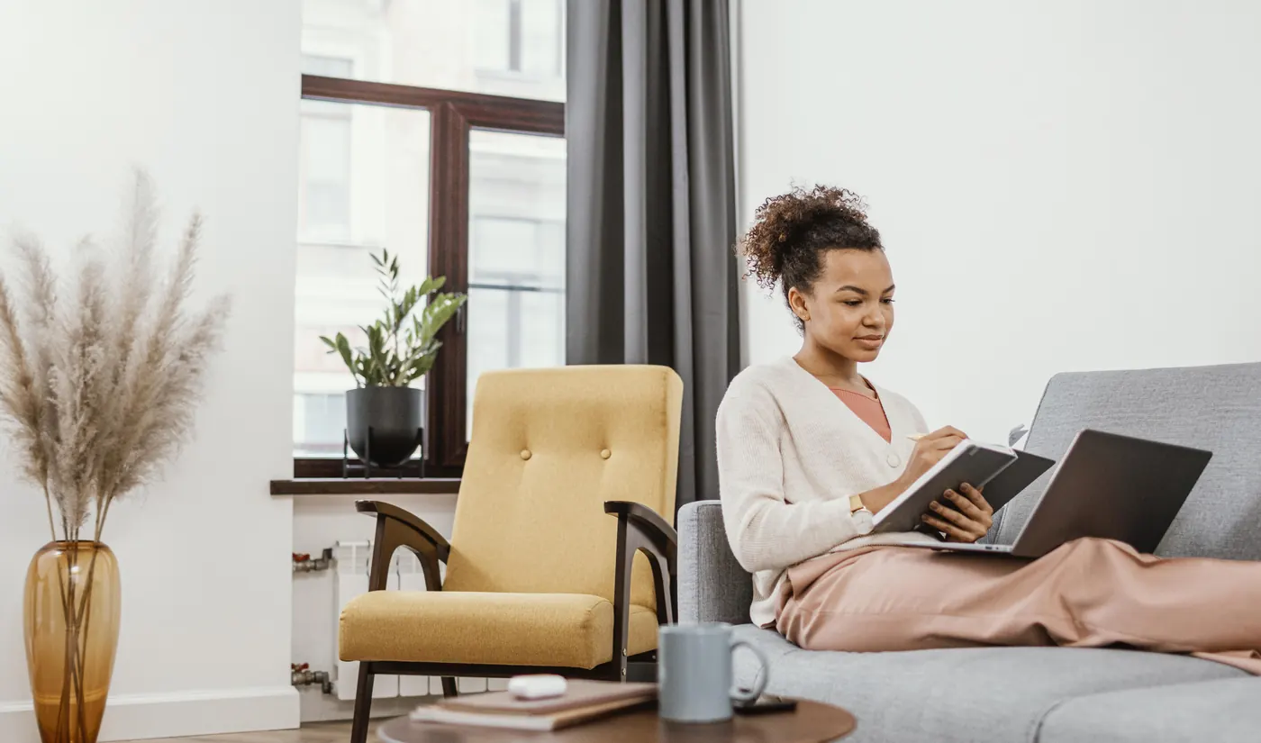 Young woman working while sitting on the sofa