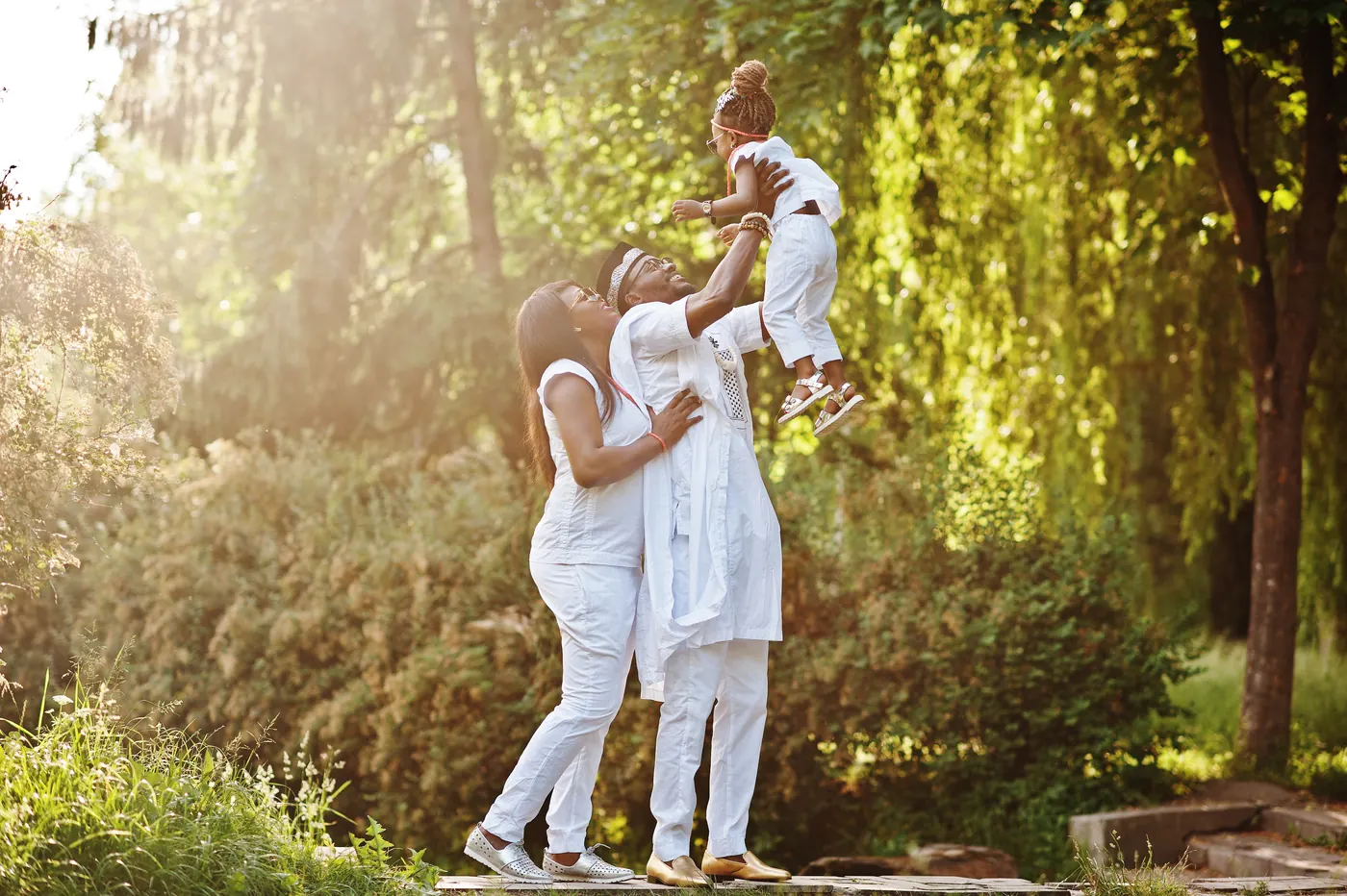 African family having fun at sunset, father throws daughter