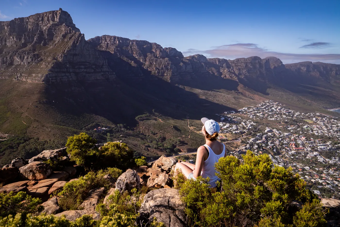 Woman sitting on cliff edge admiring Cape Town
